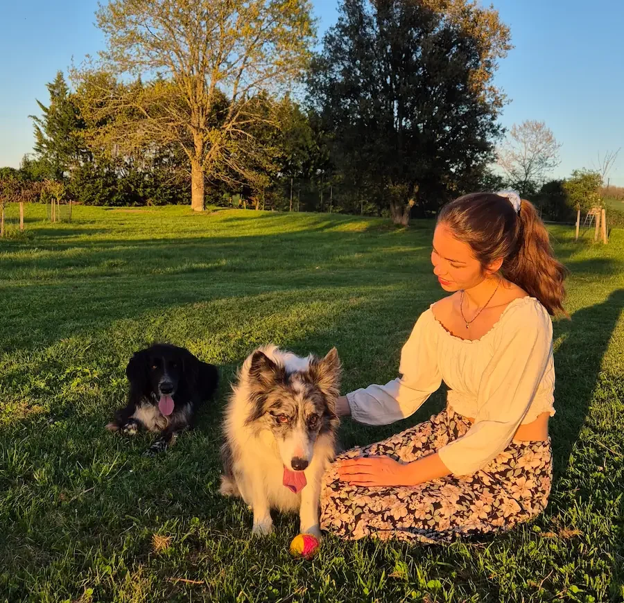 femme assise dans un jardin avec deux chiens