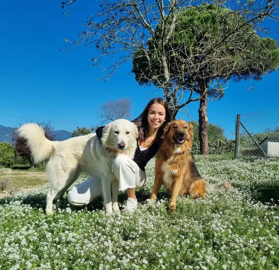 femme qui enlace deux chiens dans un jardin