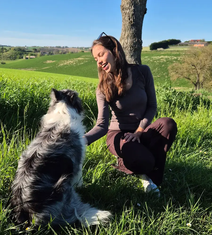 femme qui sourit avec chien dans la nature